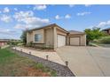 Ample parking is available in this spacious three-car garage with a paved driveway and manicured landscaping at 11064 Hermitage Run, Littleton, CO 80125