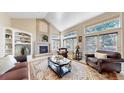 Cozy living room with fireplace, vaulted ceiling, and large windows at 1977 Champions Cir, Castle Rock, CO 80104