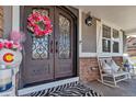 Inviting front porch showcasing decorative chairs, a wreath, and elegant double doors at 6746 S Biloxi Ct, Aurora, CO 80016