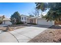 Split-level home with a large driveway, two-car garage, and a well-maintained front lawn at 2154 S Joplin Way, Aurora, CO 80013