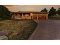 A charming single-story home with a brick exterior, two-car garage, and well-manicured lawn at 5808 Crestbrook Cir, Morrison, CO 80465