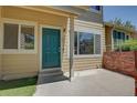 Welcoming front entrance with a vibrant green door and a cozy porch at 2181 S Troy Way # 103, Aurora, CO 80014