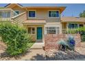 Well-kept townhome featuring a charming front entryway and lush greenery at 2181 S Troy Way # 103, Aurora, CO 80014