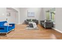 Comfortable living room with wood floors, gray sofas, a blue chair, and bright, natural light at 11383 Oakland Dr, Commerce City, CO 80640