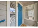 Close-up of unit front entrance, featuring stylish blue door with welcome mat at 3727 Cactus Creek Ct # 204, Highlands Ranch, CO 80126