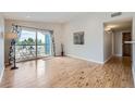 Bright living room with wood floors, leads to balcony with outdoor seating at 3727 Cactus Creek Ct # 204, Highlands Ranch, CO 80126