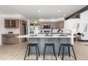 Bright kitchen with a large island with seating and modern appliances and fixtures at 5814 Cole Way, Arvada, CO 80004
