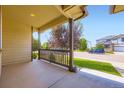 Covered front porch showcasing sturdy beams and a scenic neighborhood view, perfect for relaxing outdoors at 5770 Waverley Ave, Firestone, CO 80504