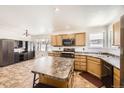 Bright kitchen with wood cabinets, an island, and modern appliances offering a functional cooking space at 5770 Waverley Ave, Firestone, CO 80504