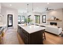 Open kitchen and living area with large island, fireplace, and hardwood floors at 3149 W 35Th Ave, Denver, CO 80211