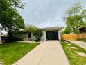 Charming one-story home with a well-maintained front yard, a new garage door, and attractive landscaping at 8307 E Lehigh Dr, Denver, CO 80237
