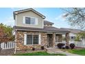 Charming two-story home featuring a stone facade, covered porch, and well-maintained lawn at 11738 Zenobia Loop, Westminster, CO 80031