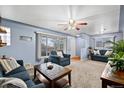 Cozy living room featuring large windows, plush seating, and a ceiling fan, offering comfort and style at 3670 Ivanhoe St, Denver, CO 80207