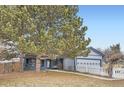 Cozy two-story home with a covered porch, two-car garage, mature trees, and a white picket fence at 7729 Beverly Blvd, Castle Pines, CO 80108
