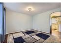 Bright, unfurnished living room space with hardwood floors, a decorative rug, and a neutral color scheme at 7729 Beverly Blvd, Castle Pines, CO 80108