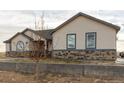 Attractive home with stone accents, neutral siding, and a well-maintained lawn at 16301 Hudson Rd, Hudson, CO 80642