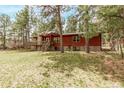 Beautiful home with a wood exterior, stone accents, an inviting deck, and a well-maintained lawn at 1150 Fremont Dr, Larkspur, CO 80118