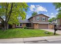 Traditional two-story home with manicured front yard and brick detailing at 8268 W Caley Pl, Littleton, CO 80123
