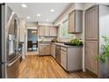 A well-lit kitchen featuring stainless steel appliances and wood-look floors at 8268 W Caley Pl, Littleton, CO 80123