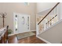 Bright foyer with hardwood floors, white trim staircase, high ceilings, and a decorative front door at 1774 Spring Water Pl, Highlands Ranch, CO 80129