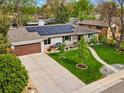 An aerial view of the landscaped front yard featuring solar panels and a driveway at 3052 S Gilpin St, Denver, CO 80210