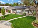 A landscaped front yard with a walkway, stone accents, and seating area outside the home at 3052 S Gilpin St, Denver, CO 80210