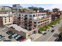 View of a well-maintained condo building with parking, balconies, and surrounding cityscape at 1435 Wazee St # 305, Denver, CO 80202
