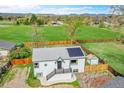Aerial view of a home with solar panels, fenced yard, and proximity to green space and mountain views at 215 Jay St, Lakewood, CO 80226