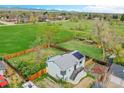 Aerial view showcasing a home's fenced backyard, with a lawn, patio area, and a lush green neighborhood at 215 Jay St, Lakewood, CO 80226