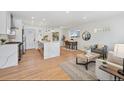 Bright open-concept featuring modern kitchen island, living, and dining areas, with hardwood floors at 3340 Leyden St, Denver, CO 80207