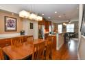 Open-concept kitchen features wooden cabinets, stainless steel appliances, and adjacent dining area at 3401 N Xenia St, Denver, CO 80238