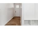 Inviting entryway with hardwood floors, a storage bench, and a white front door at 17969 Dandy Brush Ln, Parker, CO 80134