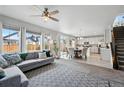 Open-concept living area with large windows, connecting to dining and modern kitchen at 27857 E 8Th Ave, Aurora, CO 80018