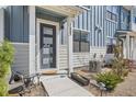 Inviting front entrance with a modern door, a seating area and a well maintained landscape at 7885 Yampa River Ave, Littleton, CO 80125