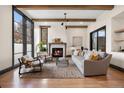 Bright living room with hardwood floors, fireplace, wooden beams and comfortable seating at 1291 S Gaylord St, Denver, CO 80210