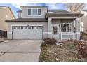 Attractive home featuring gray stucco exterior, a covered porch, and a spacious driveway leading to a two-car garage at 3869 S Himalaya Way, Aurora, CO 80013