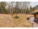 Backyard area featuring a deck with an outdoor grill and wooded background at 2720 S Spring Gulch Rd, Idaho Springs, CO 80452