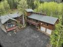 An exterior elevation showing a multi-story home with a large driveway and beautiful wooded surroundings at 2720 S Spring Gulch Rd, Idaho Springs, CO 80452
