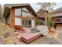 Charming outdoor deck area with seating, barrel table and steps to the house at 2720 S Spring Gulch Rd, Idaho Springs, CO 80452
