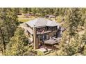Exterior aerial view of a two-story home featuring multiple decks and surrounded by lush trees at 20496 Stonewood Trl, Morrison, CO 80465