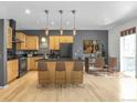 Kitchen with light wood cabinets, black appliances, and a dining area at 1438 Little Raven St # 201, Denver, CO 80202