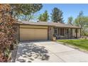 Spacious driveway leading to an attached garage, bordered by lush greenery and a well-maintained lawn at 904 Fieldstone Pl, Highlands Ranch, CO 80126