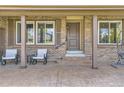 Inviting front porch with seating area, a porch swing, brick facade and charming exterior details at 904 Fieldstone Pl, Highlands Ranch, CO 80126