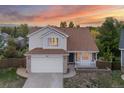 Charming home showcases a well-kept lawn, pristine driveway, attached garage, and inviting front porch at 3087 Deer Creek Trl, Highlands Ranch, CO 80129