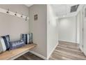 Inviting entryway with wood bench, storage hooks, accent pillows, and modern flooring for a welcoming arrival at 2525 S Dayton Way # 2209, Denver, CO 80231