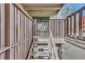 View of home's staircase and gated entrance, featuring a wood-toned railing, steps, and address marker at 2525 S Dayton Way # 2209, Denver, CO 80231