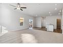 Spacious living room with carpet, slider to the outdoors, fan and easy access to the modern kitchen at 3004 Oxley St, Strasburg, CO 80136