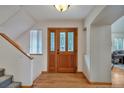 Elegant entryway with hardwood floors, a decorative glass door, and stairs leading to the upper level at 9590 S Warhawk Rd, Conifer, CO 80433