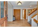 Inviting entryway featuring hardwood floors, a wood door, and a staircase leading to the upper level at 9590 S Warhawk Rd, Conifer, CO 80433