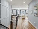 Bright living room with hardwood floors, light walls, white couches, and view into additional living space at 17880 Weymouth Ave, Parker, CO 80134